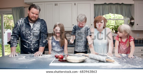 an angry family in the kitchen after a food\
fight and baking an apple pie.      \
