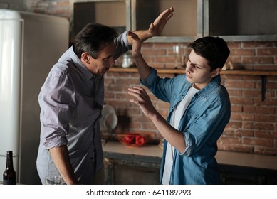 Angry Father Lifting His Arm On Son