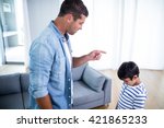 Angry father scolding his son in living room at home