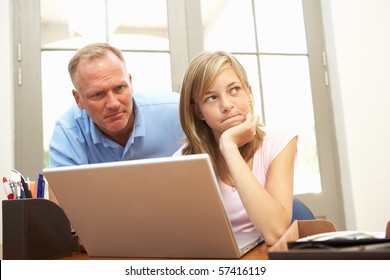 Angry Father And Teenage Daughter Using Laptop At Home