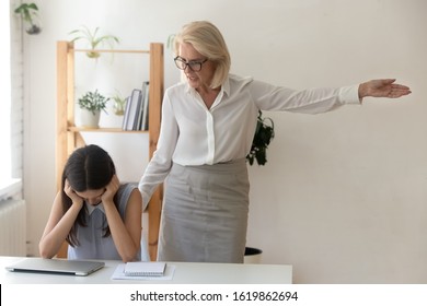 Angry female boss dismissing frustrated girl subordinate, annoyed employer telling unprofessional employee to get out pointing with hand to door fired from job, losing work, becoming jobless concept