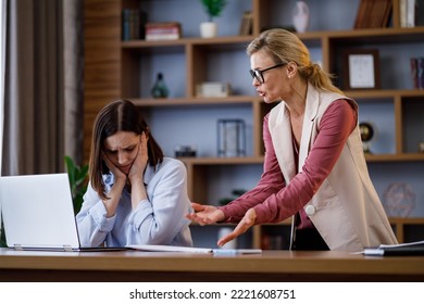 Angry female boss scolding scared office worker. Demanding manager leader is annoyed at laziness and mistakes in work of employee. Authoritarian leadership, abuse of power, malfeasance in office - Powered by Shutterstock