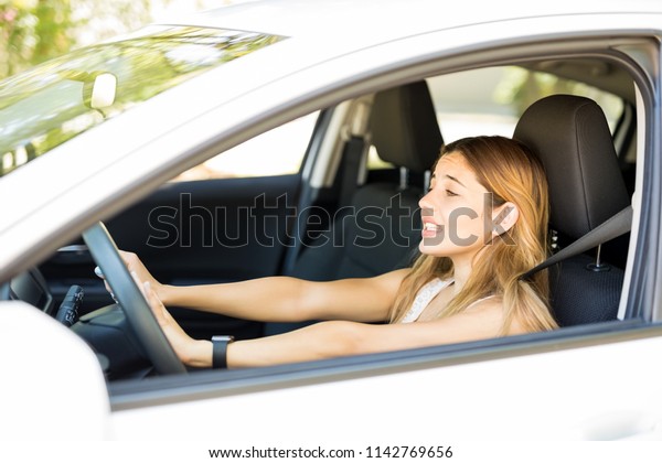 Angry
female driver honking the car horn in traffic
jam
