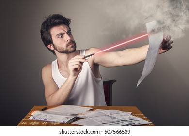 Angry Frustrated Young Man Burning Paper Bills With His Laser Pen