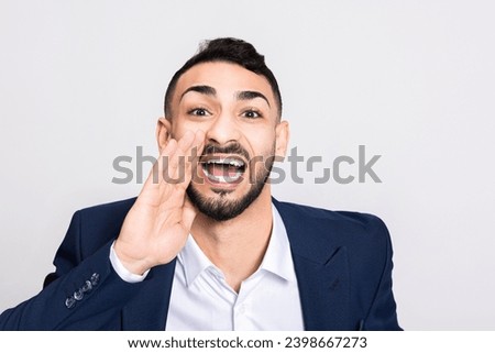 Angry furious man standing over grey background in studio isolated wearing ellegant black suit holding hands near face head looking at camera in bad mood posing while shooting process. Stock photo © 