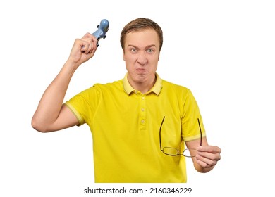 Angry gamer with wireless gamepad dressed in yellow T-shirt isolated on white background. Furious man throwing game joystick in TV, loss in video game concept, video game addiction