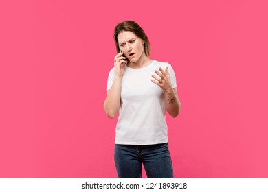 angry girl talking on smartphone and gesturing by hand isolated on pink - Shutterstock ID 1241893918