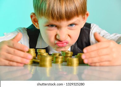 Angry and greedy child holds their money coins. The concept of greed, greed and vice from childhood. - Shutterstock ID 1329325280