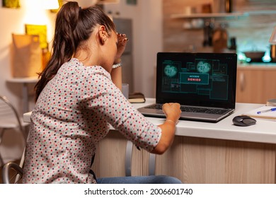 Angry hacker woman because of access denied while trying to attack government firewall. Programmer writing a dangerous malware for cyber attacks using performance laptop during midnight.