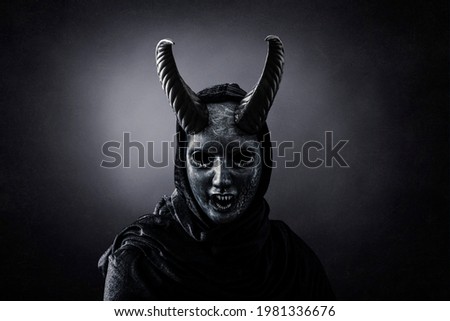Angry horned demon in the dark