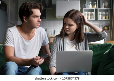 Angry Husband Holding Credit Card Blaming Wife Spender Of Overspending Wasting Too Much Money On Online Shopping, Millennial Couple Arguing About Budget Expenses Having Financial Problems Or Debt