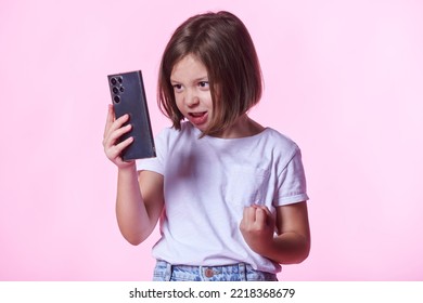 Angry, Irritated Girl Child Shouting At The Phone, Pink Studio Background