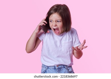 Angry, Irritated Girl Child Shouting On The Phone, Pink Studio Background