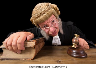Angry judge in extreme wide angle closeup with hammer and wig