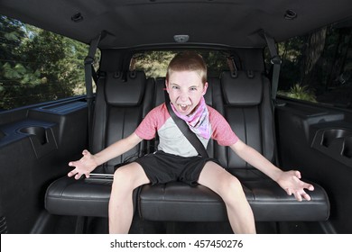 An Angry Kid Sitting In The Back Seat Of The Car