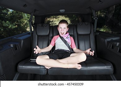 An Angry Kid Sitting In The Back Seat Of The Car