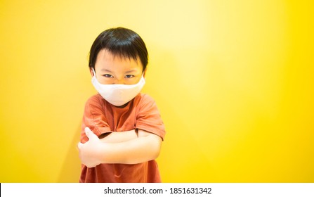 Angry Kid Wearing Mask On Yellow Background.stubborn Kid Boy Looking And Fighting With Mom.Furious Toddler Kid Got Upset.Lockdown At Home.Depressed Toddler Boy Complaining.Healthcare During Covid19.