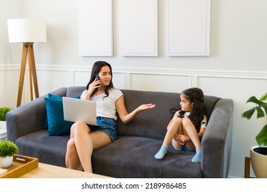 Angry Latin Mom Working And Talking On The Phone While Scolding Her Young Daughter For Bad Behavior 