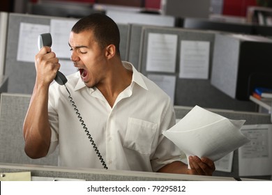 Angry Latino office worker yells on phone