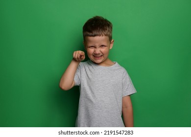 Angry Little Boy On Green Background. Aggressive Behavior