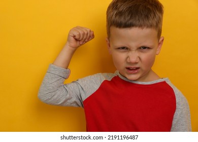 Angry Little Boy On Yellow Background. Aggressive Behavior
