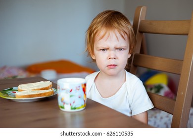 An angry little boy and a sandwich with butter. - Powered by Shutterstock