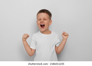Angry Little Boy Screaming On White Background. Aggressive Behavior