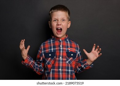 Angry Little Boy Screaming On Black Background. Aggressive Behavior