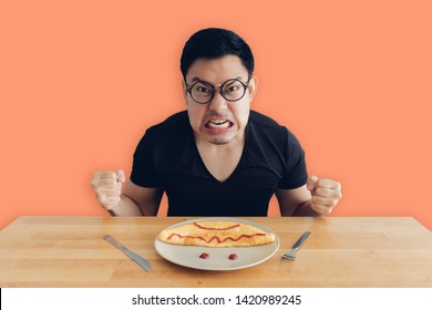 Angry And Mad Face Of Asian Man Is Eating Homemade Breakfast Set Of Omelet.