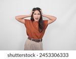 The angry or mad face and gesture of Asian woman in brown shirt on isolated white background.