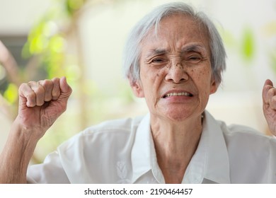 Angry mad senior woman raising fists,facial expression,enraged old elderly grimacing,unpredictable changes of mood,upset,moody,grouchy and irritable,emotional problems,affective disorder,mental health - Shutterstock ID 2190464457