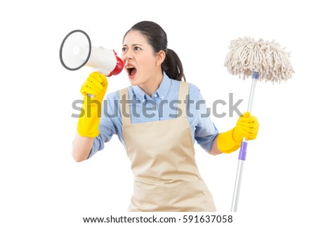 angry mad young housewife using loudspeaker to call her kids to cleanup of the mess with holding a mop. isolated on white background. mixed race asian chinese model.