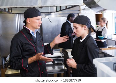 Angry male chef talking to his female assistant in commercial kitchen.. - Powered by Shutterstock