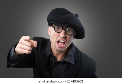 Angry man in a beret pointing at camera