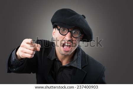 Angry man in a beret pointing at camera