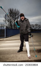 Angry Man With Broken Leg In Gypsum Hardly Move On Winter Outdoor Location With Crutches