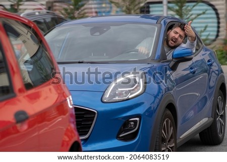 Angry man in the car in the queue yells at the driver in front