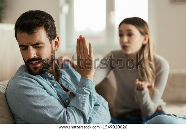 Angry man doesn\'t pay attention to his\
girlfriend who is asking for his\
forgiveness.