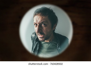 Angry Man At The Door Viewed Through Spy Hole, Debt Collector Or Criminal Knocking At The Door