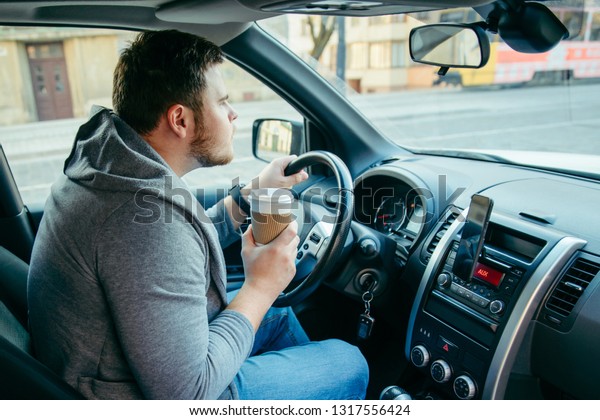 angry man driving car and drinking coffee.
traffic collapse.
lifestyle