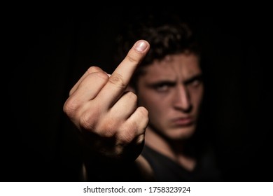 Angry man expressing abhorrence in dark backround. dramatic lights