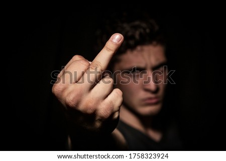 Angry man expressing abhorrence in dark backround. dramatic lights