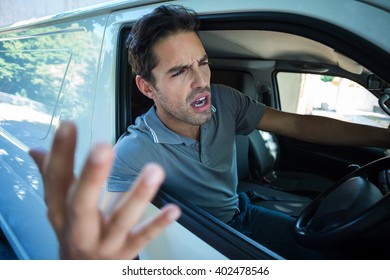 An Angry Man Is Gesturing With His Hand While Sitting In Car