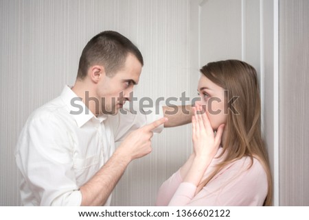 Angry man, pointing her finger against her wife, intimidates, unhappy married couple, relationships concept