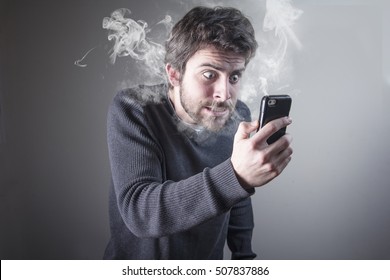 Angry man shouting at his cell phone, enraged with the bad service, burning with rage