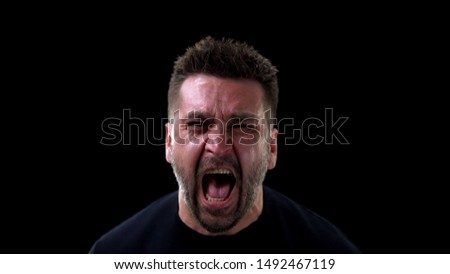 Angry man shouting on dark background, emotional breakdown, outburst neurosis
