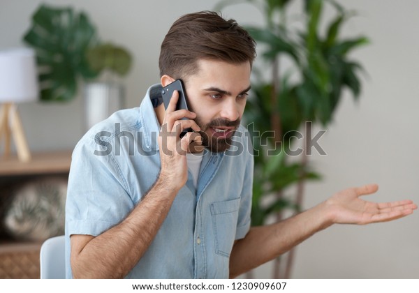 Angry man talk on smartphone arguing or\
solving problem, irritated male have cell phone conversation manage\
work trouble, annoyed guy use mobile call customer service\
disputing or complaining
