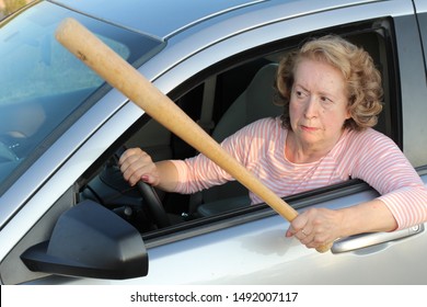 Angry mature female driver holding baseball bat  - Shutterstock ID 1492007117
