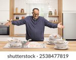 Angry mature man in a messy kitchen with dirty dishes