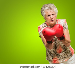 Angry Mature Woman Wearing Boxing Glove Isolated On Green Background